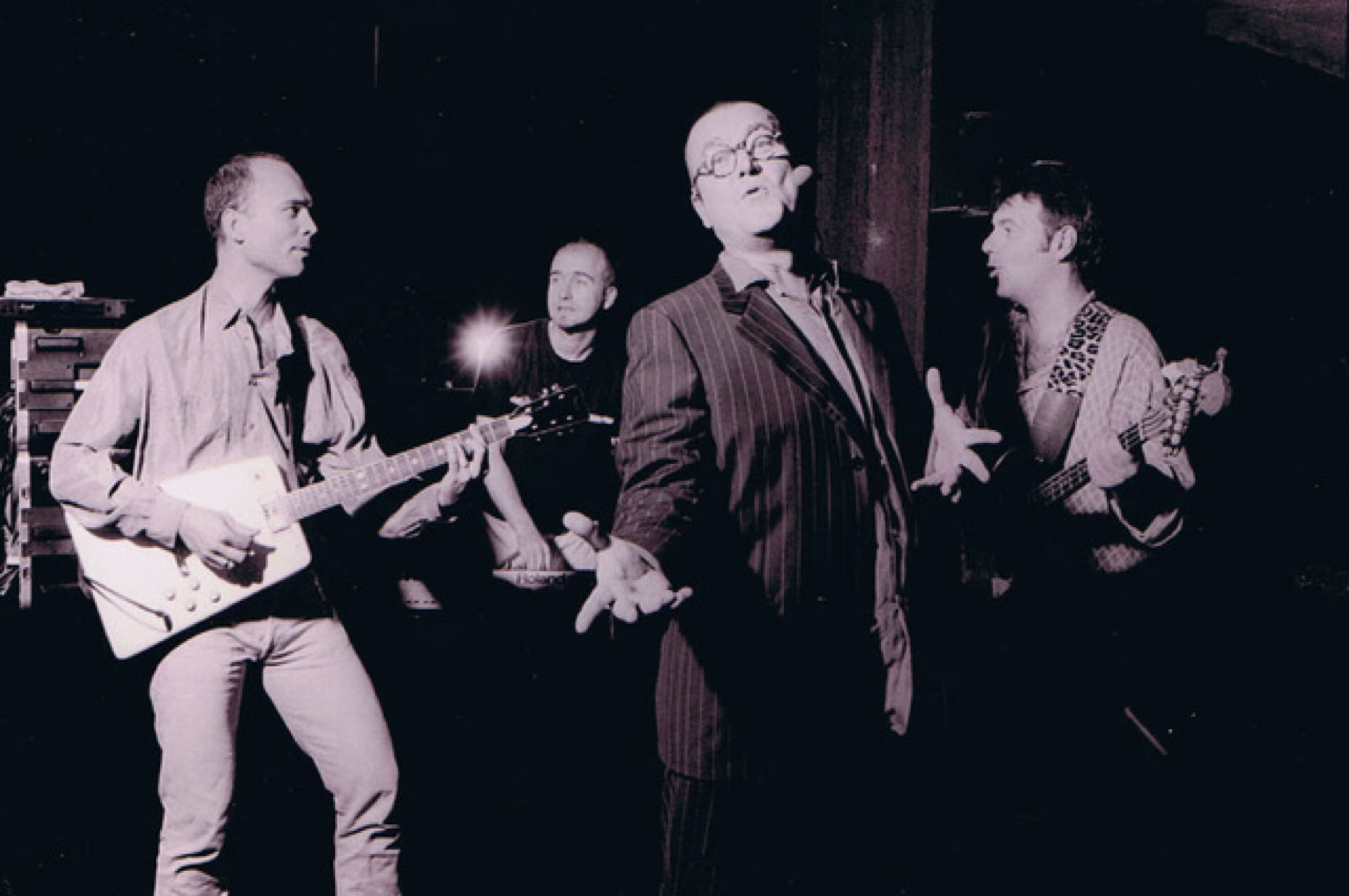 Lutz G&ouml;rner mit drei weiteren Personen auf einer B&uuml;hne, einer spielt Gitarre, ein anderer singt, die anderen beiden spielen Instrumente im Hintergrund.